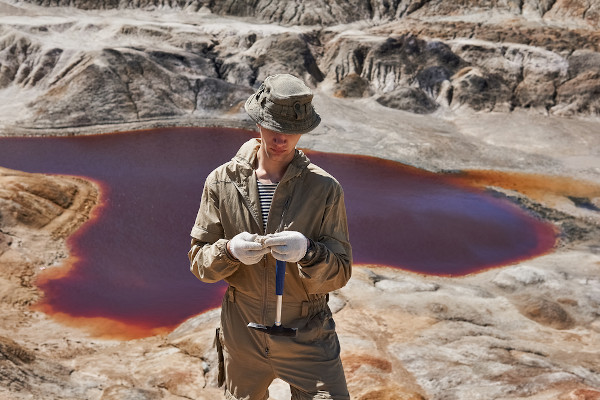 Geólogo, o profissional da área de Geologia, analisando as rochas de um determinado lugar.